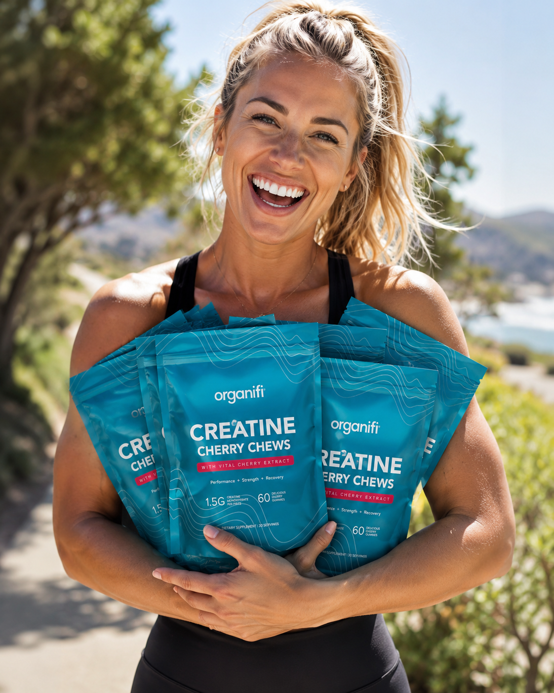 Smiling woman holding Organifi Parasite Cleanse bottles